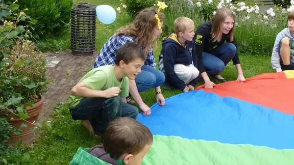 5 kinderen spelen met de parachute