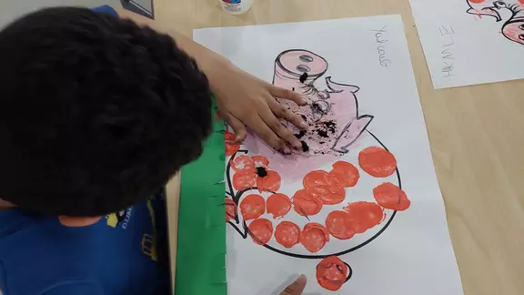 kinderen stempelen met hun vingers bruine vlekken op een afbeelding van een varken