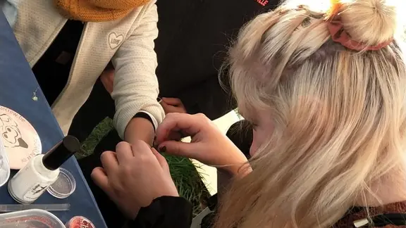 animator zet een glittertattoo