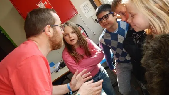 4 kinderen en filip bespreken iets in een kringgesprek