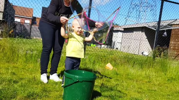 klein meisje maakt zeepbellen met behulp van een anmimator
