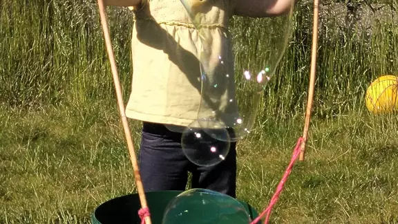 klein meisje probeert zeepbellen te maken