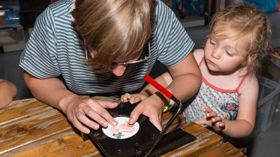 moeder en dochter maken samen een button.