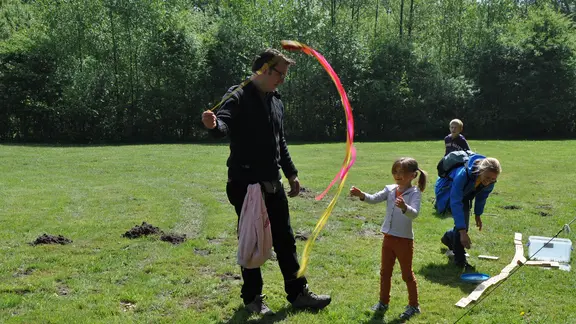 animator speelt met lange linten. 3 kinderen spelen mee