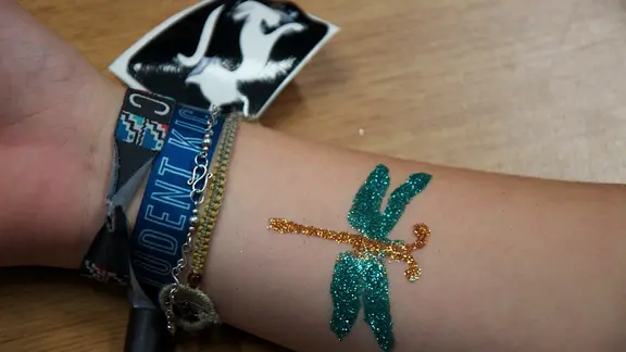 afgewerkte glittertattoo libel op de arm