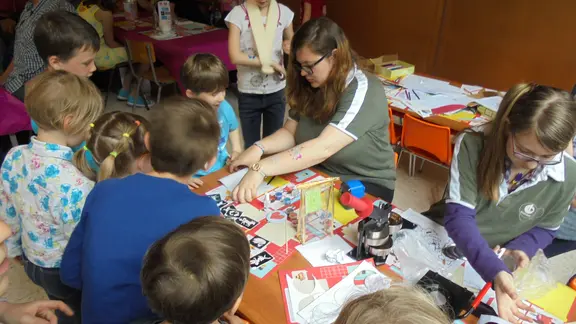 groep kinderen en docenten rond een tafel