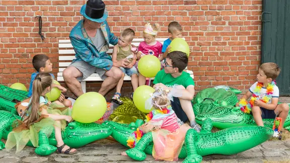 groep verkleedde kinderen/volwassenen met opblaaskrokodillen