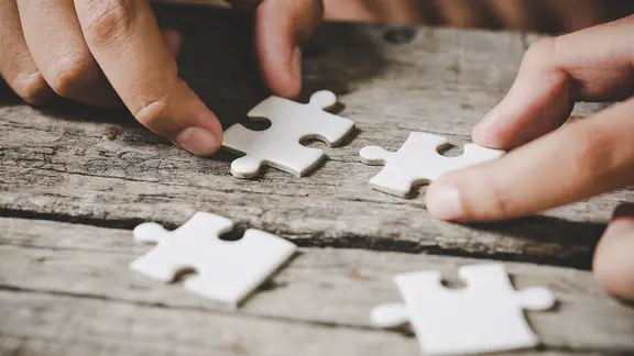 4 puzzelstukken en 2 handen