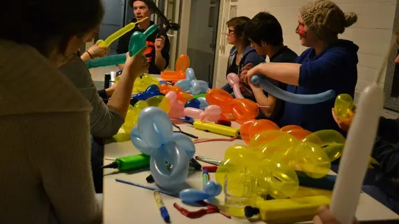 tafel vol met ballonnen en enkele deelnemers er rond