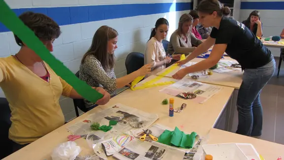 deelnemers aan een tafel volgen de workshop gekke kapsels