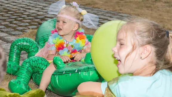 2 kinderen verkleed op opblaaskrokodillen