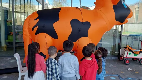 kinderen melken een opblaasbare melkkoe