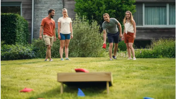 grasveld met spelbord en mensen die het spel spelen