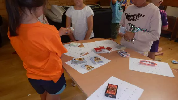 kinderen rond een tafel kijken naar elkaars trucjes
