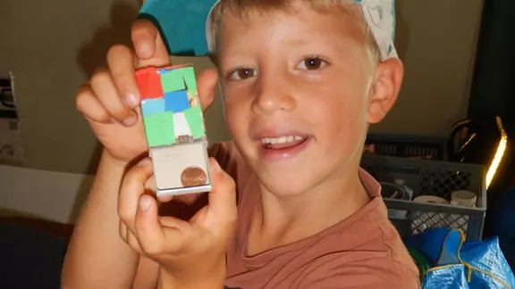 1 kind met pet toont een knutselwerkje thema goochelen