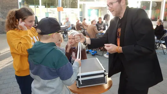 filip heeft een koffer en staat op een speelplaats een goocheltruc uit te voeren