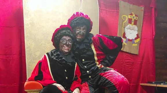 2 pieten zitten in de sinterklaasstoel