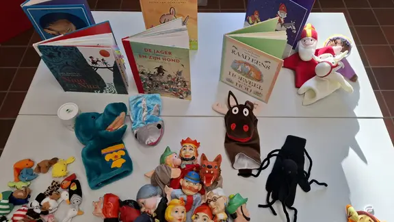 tafel met leesboeken en handpoppen