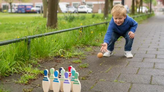 kind speelt het bowlingspel buiten